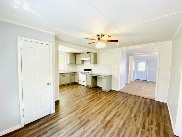 a view of a kitchen with kitchen island a sink stainless steel appliances and cabinets