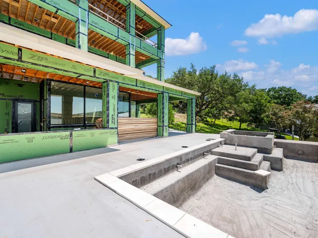 a view of a house with a balcony and floor to ceiling windows