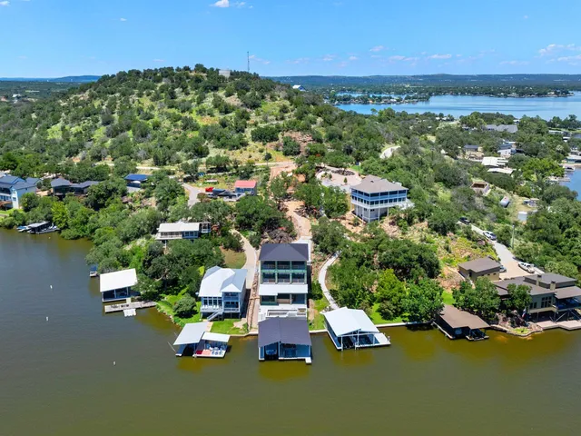 an aerial view of lake and residential houses with outdoor space