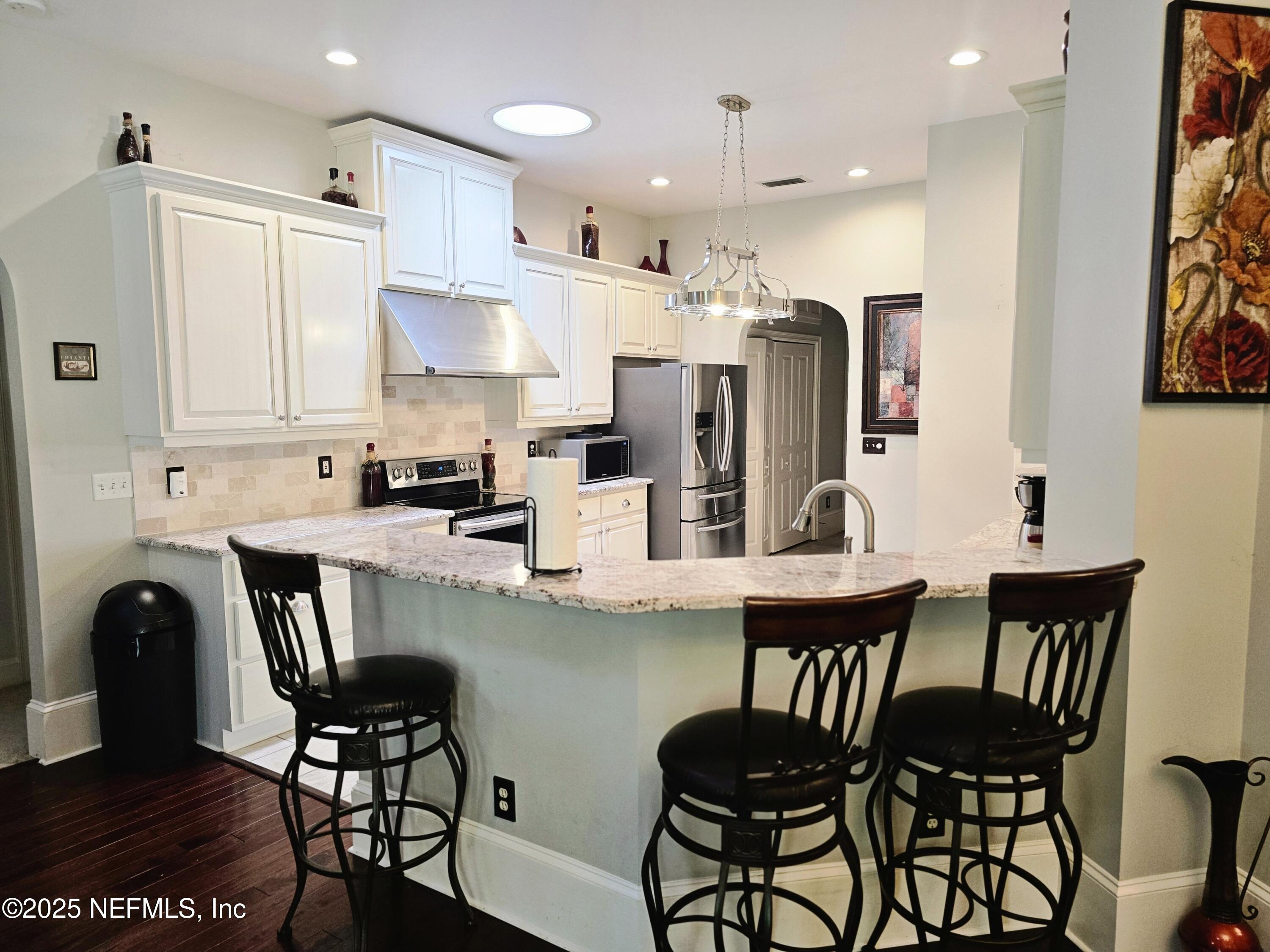 3600 Stratton Road Jacksonville, FL 32221 - Photo 2 of 10 a kitchen with stainless steel appliances kitchen island granite countertop a table chairs and a refrigerator