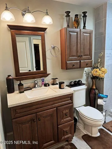 a bathroom with a toilet a sink and mirror