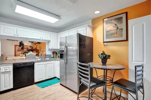 a kitchen with stainless steel appliances kitchen island granite countertop a refrigerator and a stove top oven