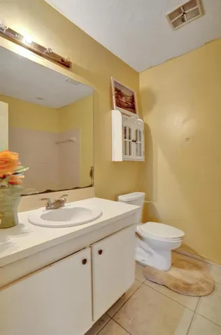 a bathroom with a sink mirror vanity and toilet