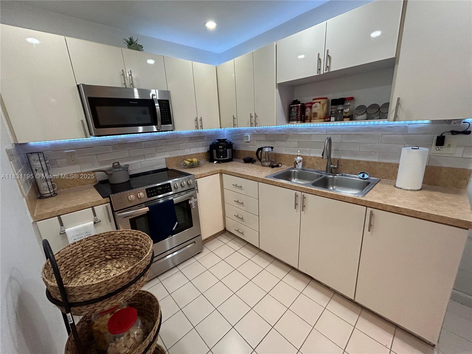 a kitchen with granite countertop a sink stainless steel appliances and cabinets
