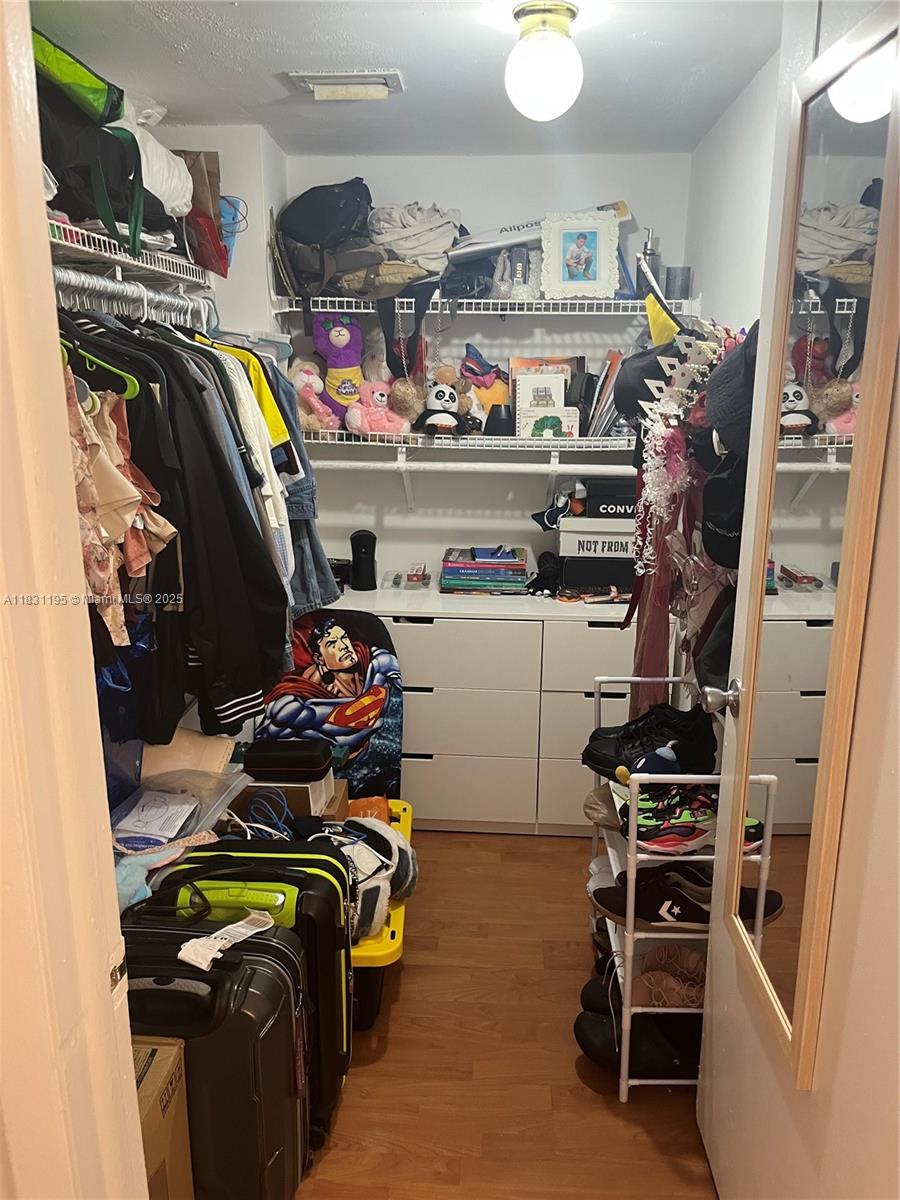 8251 Northwest 8th Street, Unit 214 Miami, FL 33126 - Photo 11 of 19 a view of walk in closet with clothes and shoes