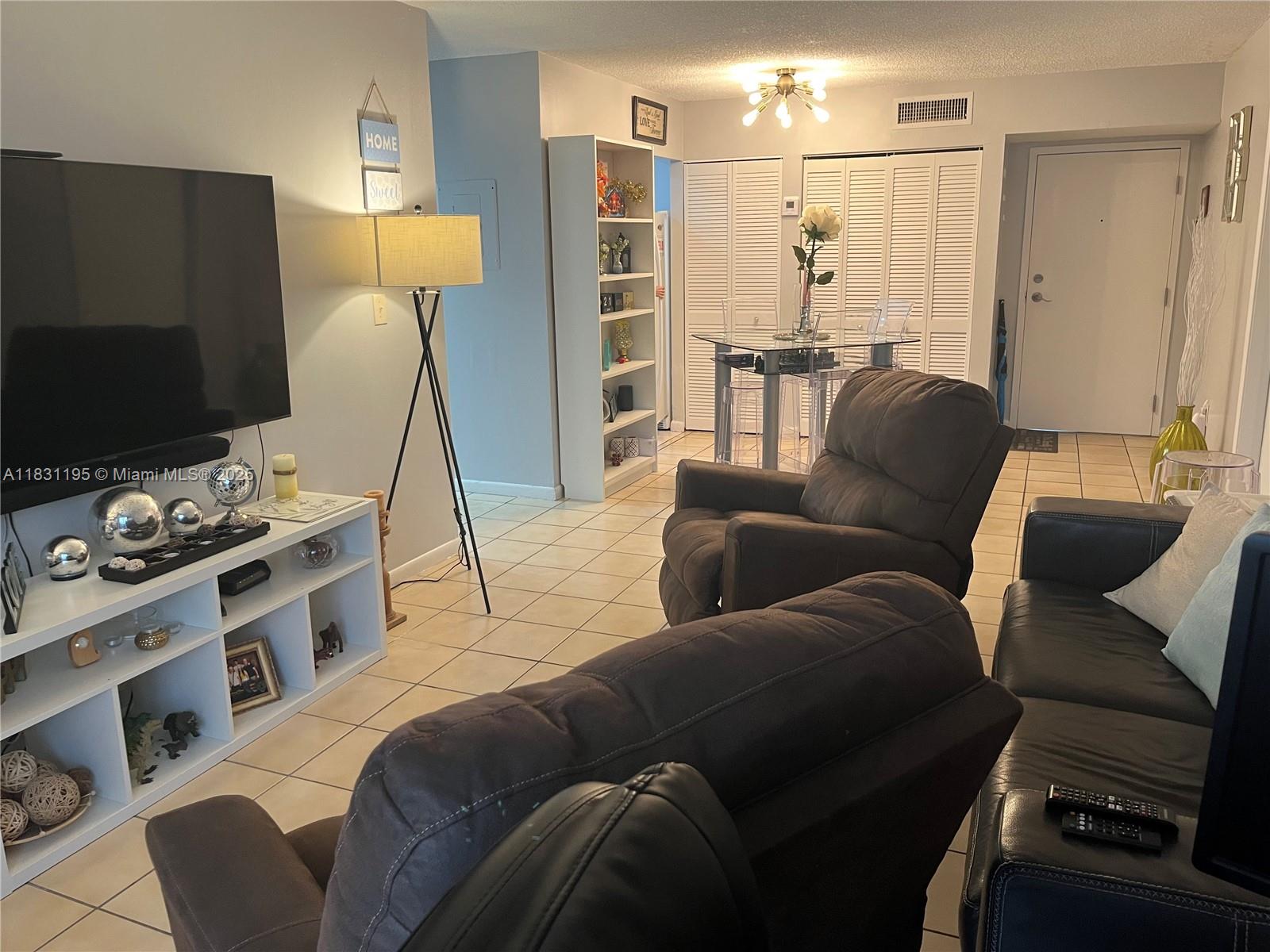 8251 Northwest 8th Street, Unit 214 Miami, FL 33126 - Photo 7 of 19 a living room with furniture and a flat screen tv