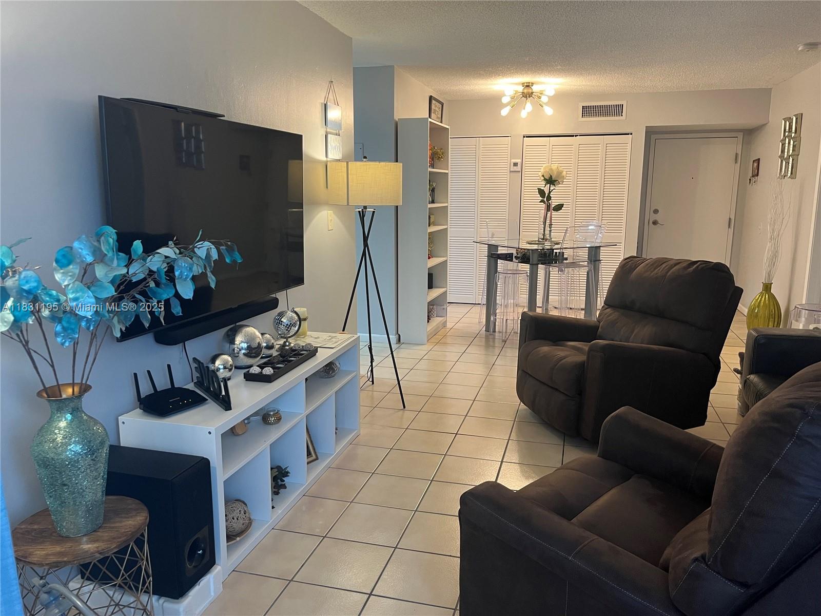 8251 Northwest 8th Street, Unit 214 Miami, FL 33126 - Photo 8 of 19 a living room with furniture and a flat screen tv