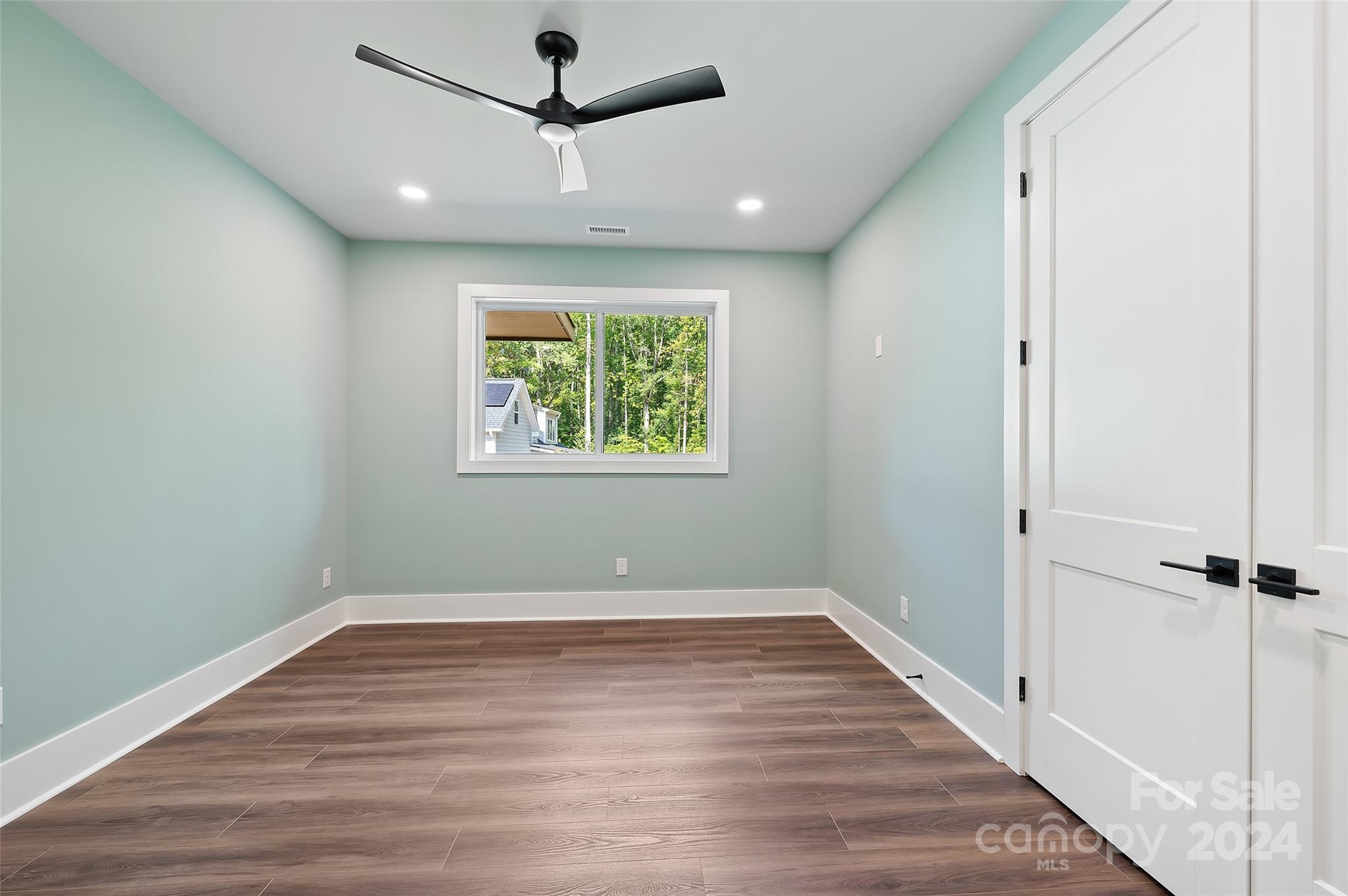 553 Evergreen Road Clover, SC 29710 - Photo 31 of 42 an empty room with wooden floor ceiling fan and windows
