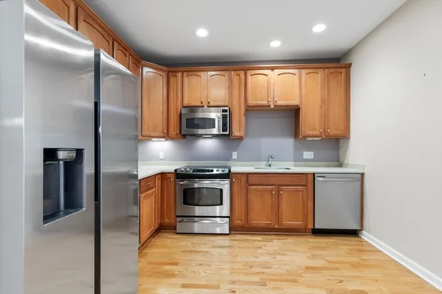 a kitchen with stainless steel appliances granite countertop a stove a sink and a refrigerator