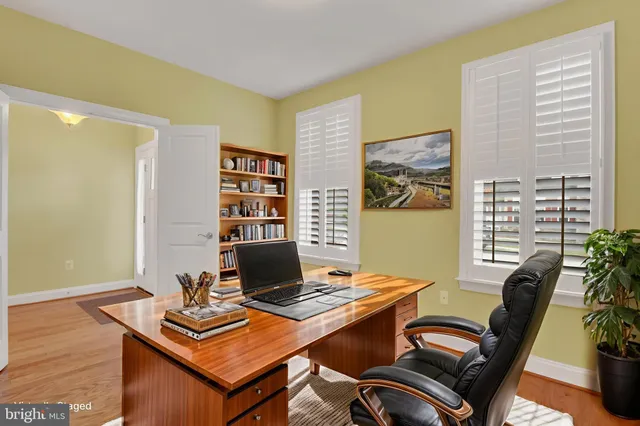 a view of a workspace with furniture and a window