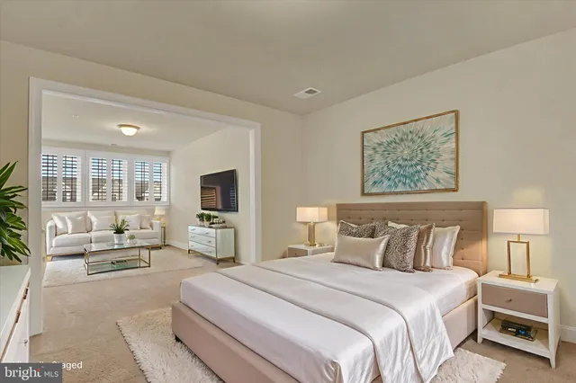 a bedroom with a large bed a flat tv screen and a couch