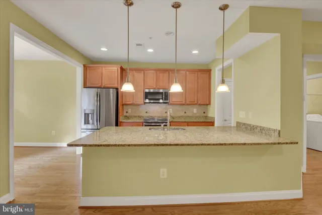 a view of a kitchen with kitchen island a sink wooden floor and a counter top space