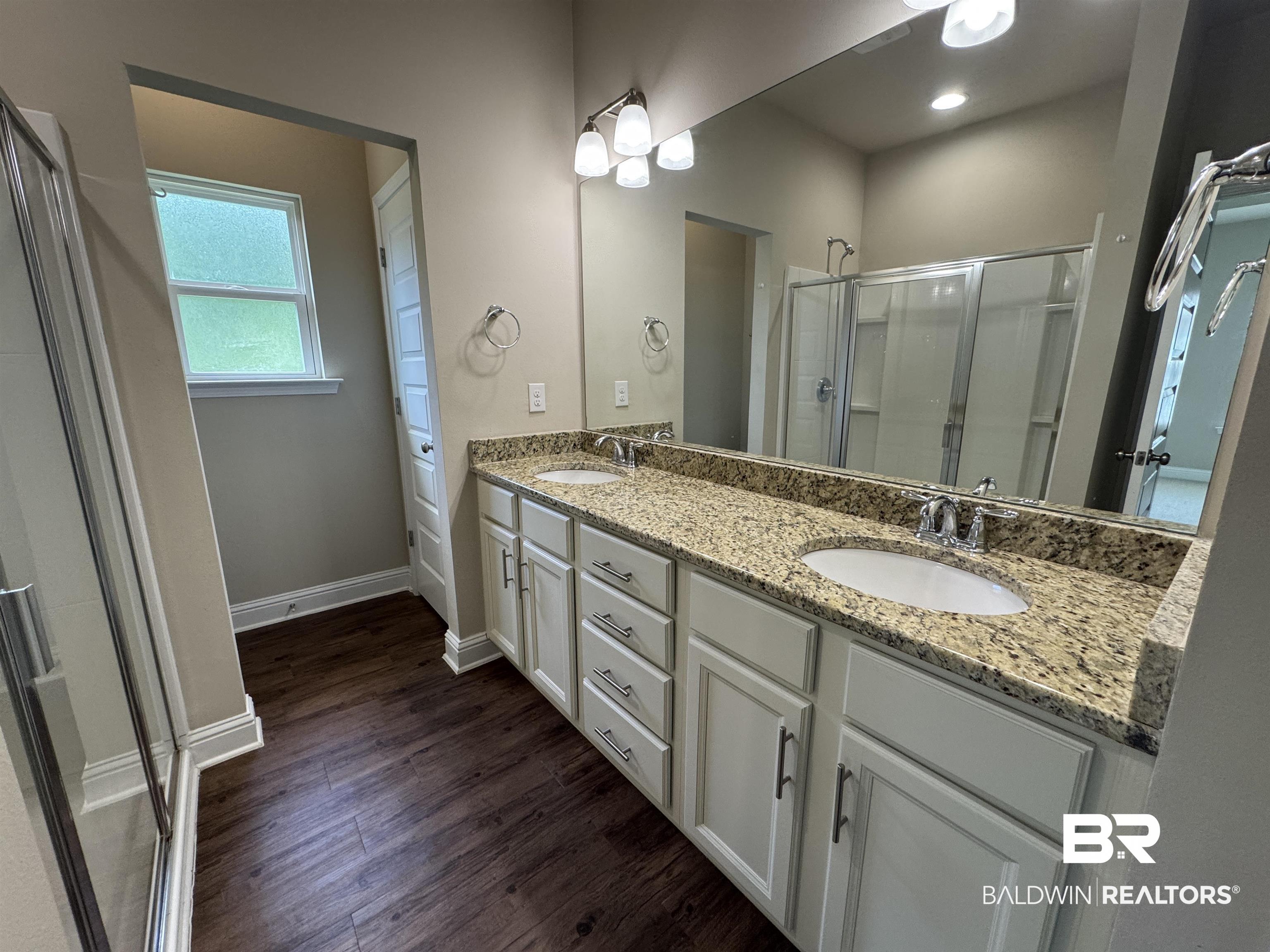 6811 Spaniel Drive, Unit C Daphne, AL 36527 - Photo 15 of 33 Bathroom featuring a shower stall, wood finished floors, double vanity, and baseboards
