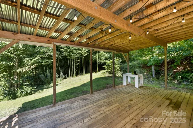 a porch with a table and chairs next to a yard