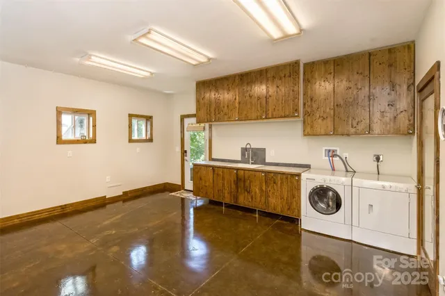a view of a kitchen with kitchen island stainless steel appliances wooden floor and living room view