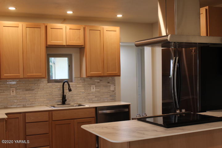 440 Gurley Road Granger, WA 98932 - Photo 3 of 25 a kitchen with kitchen island a sink appliances and cabinets