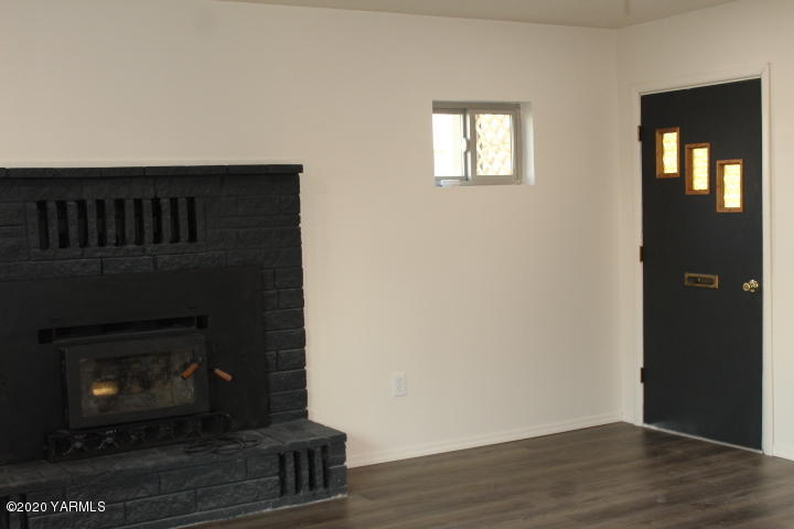 440 Gurley Road Granger, WA 98932 - Photo 10 of 25 a living room with a fireplace and a wooden floor
