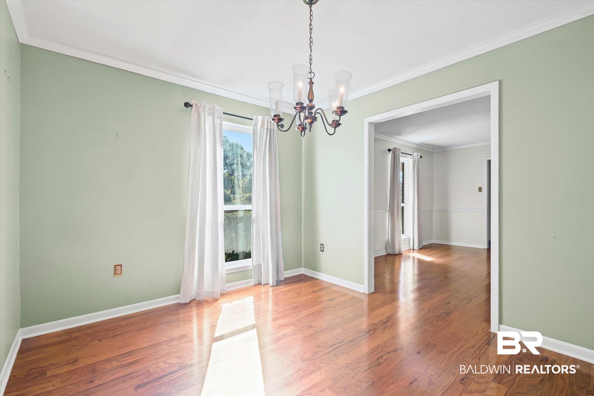 6300 Christopher Drive North Mobile, AL 36609 - Photo 5 of 22 Unfurnished dining area featuring crown molding, a chandelier, and wood finished floors