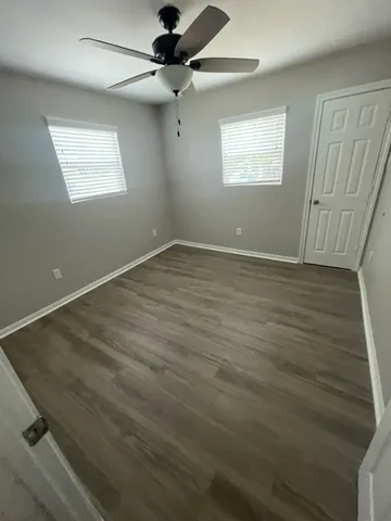 wooden floor in an empty room with a window