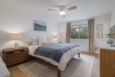 a bedroom with a bed and a tv on the dresser
