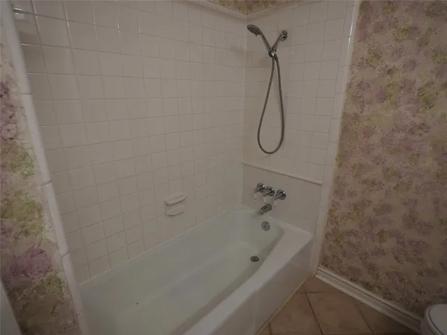a bathroom with a bath tub with a shower
