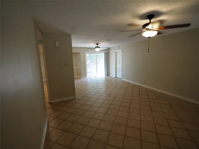 a view of a livingroom with a chandelier fan and window