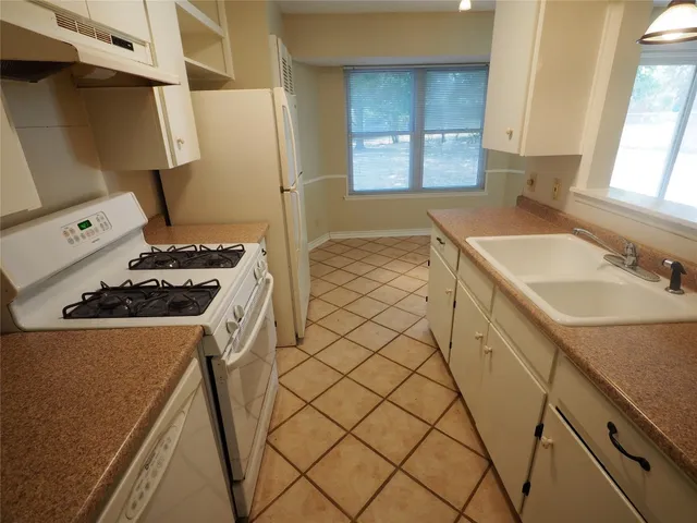 a kitchen with a sink a stove and a refrigerator