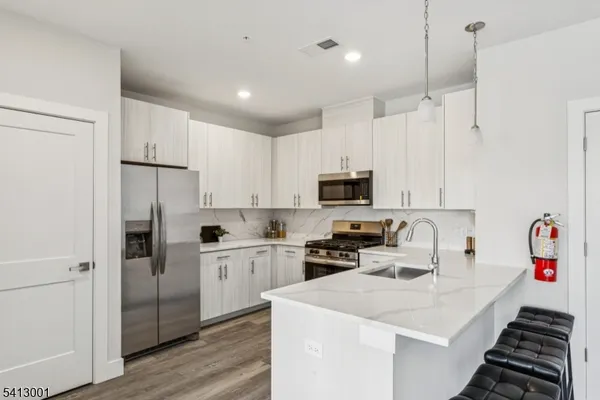 a kitchen with white cabinets and stainless steel appliances