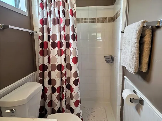 a living room with furniture and a dining table with wooden floor