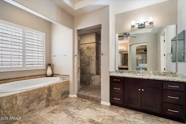 a spacious bathroom with a granite countertop sink a toilet a mirror and shower
