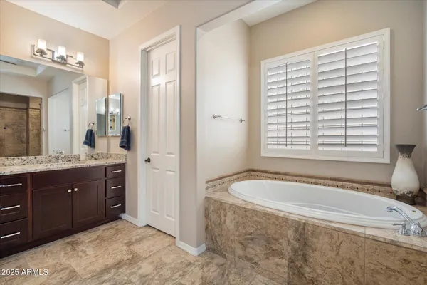 a spacious bathroom with a tub sink and mirror