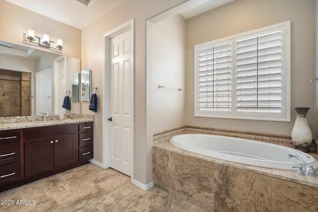 a spacious bathroom with a tub sink and mirror