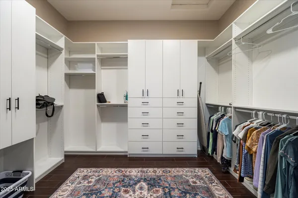 a view of walk in closet with clothes and shoes