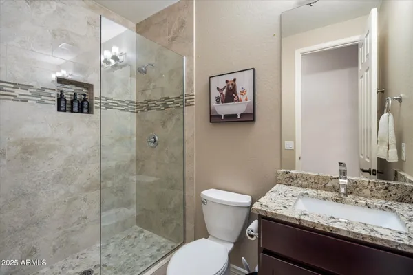 a bathroom with a granite countertop toilet sink and shower
