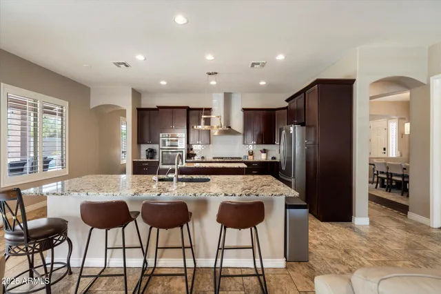 a kitchen with refrigerator cabinets and chairs