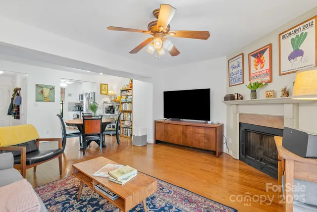 a living room with furniture a flat screen tv and kitchen view