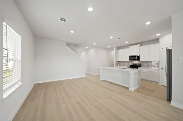 a view of kitchen with kitchen island white cabinets and refrigerator