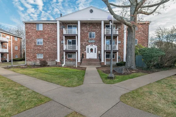 front view of a brick house with a yard