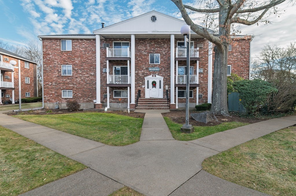 front view of a brick house with a yard