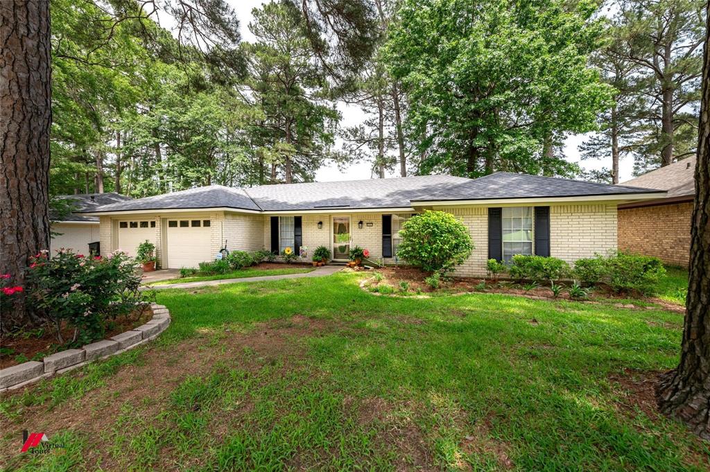 a view of a house with a yard and potted plants