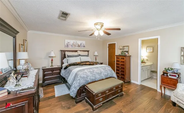 a bedroom with a bed and dresser with chair