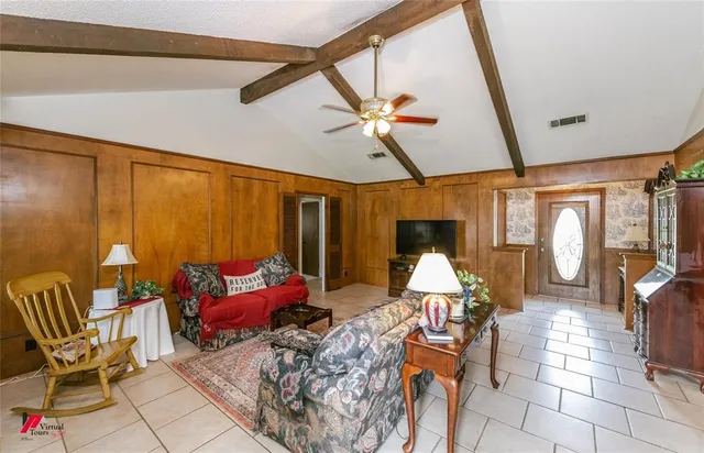 a living room with furniture a flat screen tv and floor to ceiling window