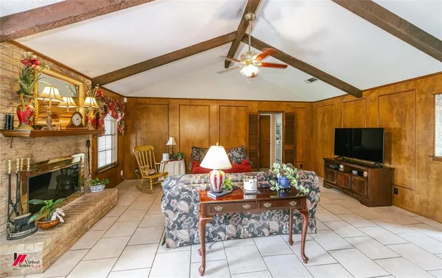 a living room with furniture a fireplace and a flat screen tv