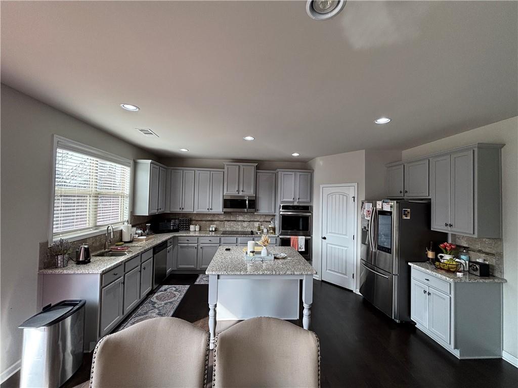 3459 In Bloom Way Auburn, GA 30011 - Photo 28 of 35 a kitchen with refrigerator a stove and chairs