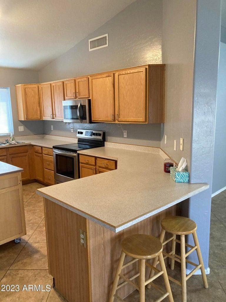 16645 North 19th Street Phoenix, AZ 85022 - Photo 7 of 11 a kitchen with a stove a sink and a refrigerator