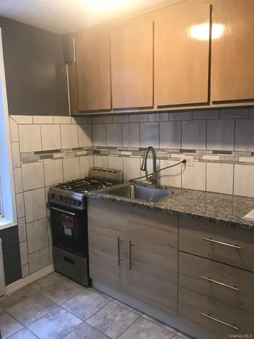 a kitchen with granite countertop a sink and a stove