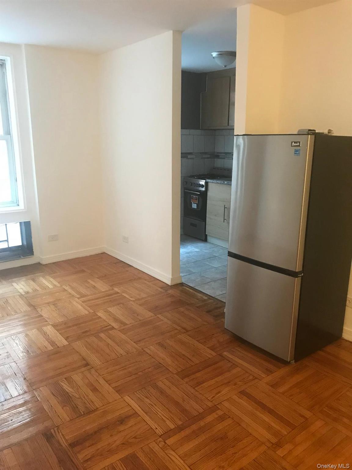1332 Metropolitan Avenue, Unit 2A Bronx, NY 10462 - Photo 7 of 15 a view of a room with a refrigerator and a microwave
