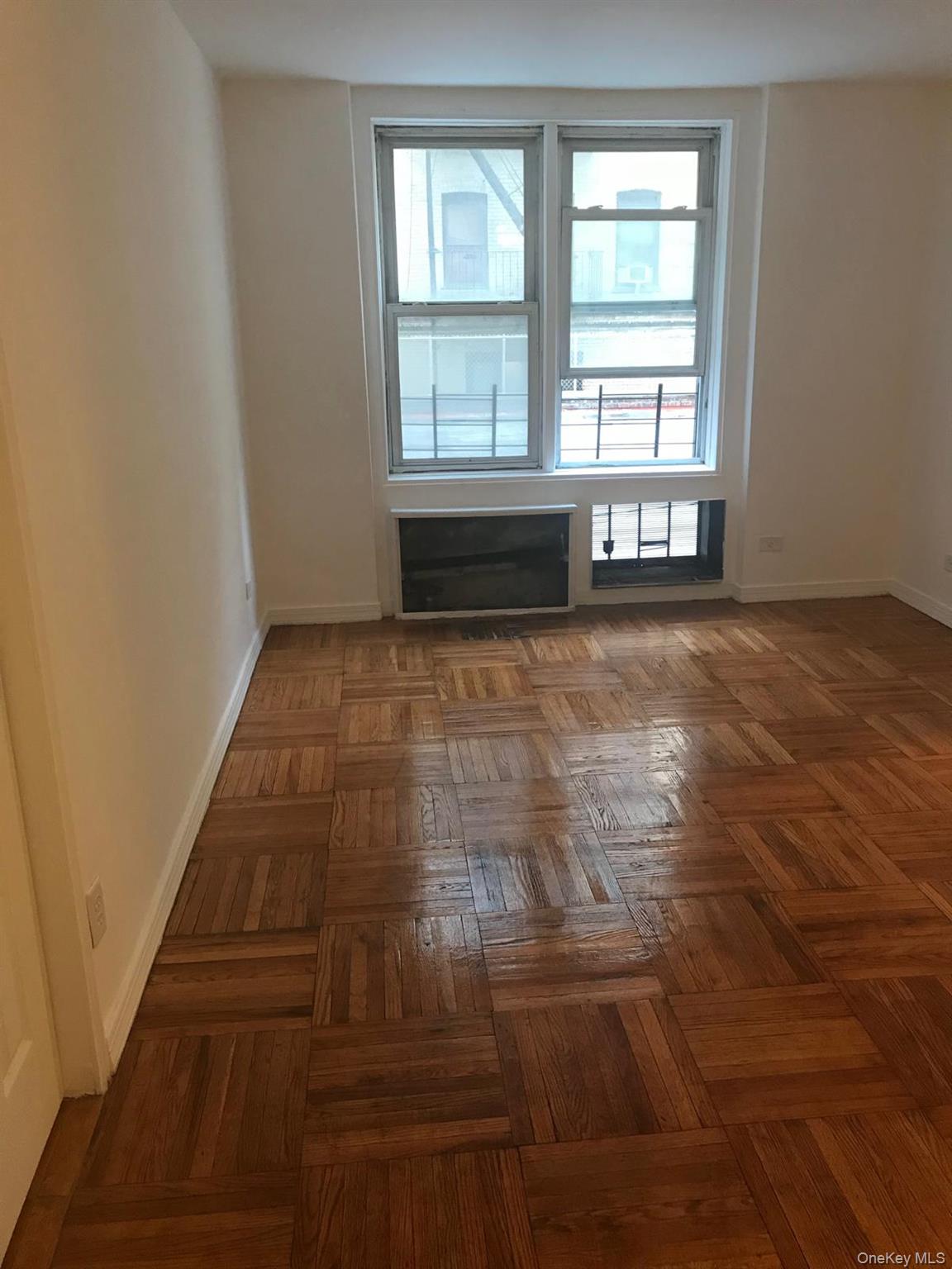 1332 Metropolitan Avenue, Unit 2A Bronx, NY 10462 - Photo 10 of 15 an empty room with wooden floor and windows