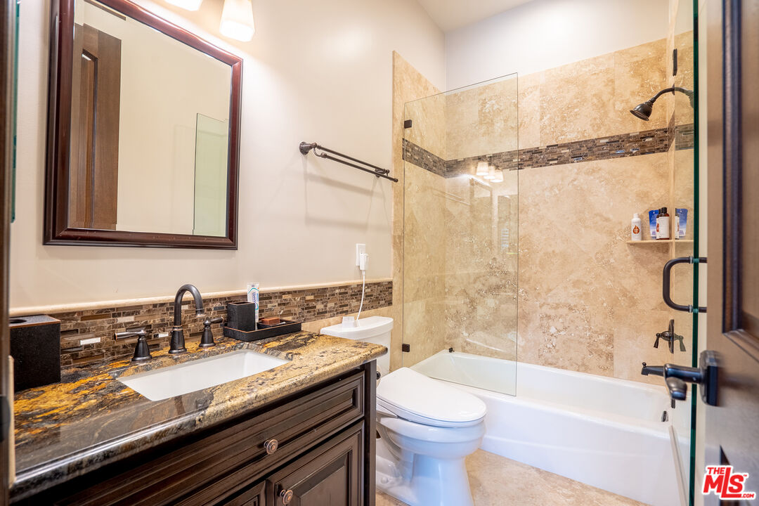 2510 Belleview Road Upland, CA 91784 - Photo 67 of 75 a bathroom with a granite countertop sink a toilet a mirror and shower
