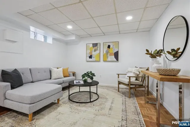 a living room with furniture a rug and a mirror